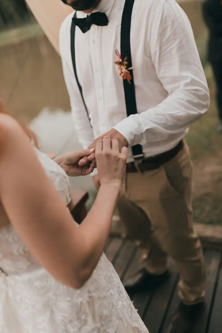Troca de alianças, mãos do casal em close